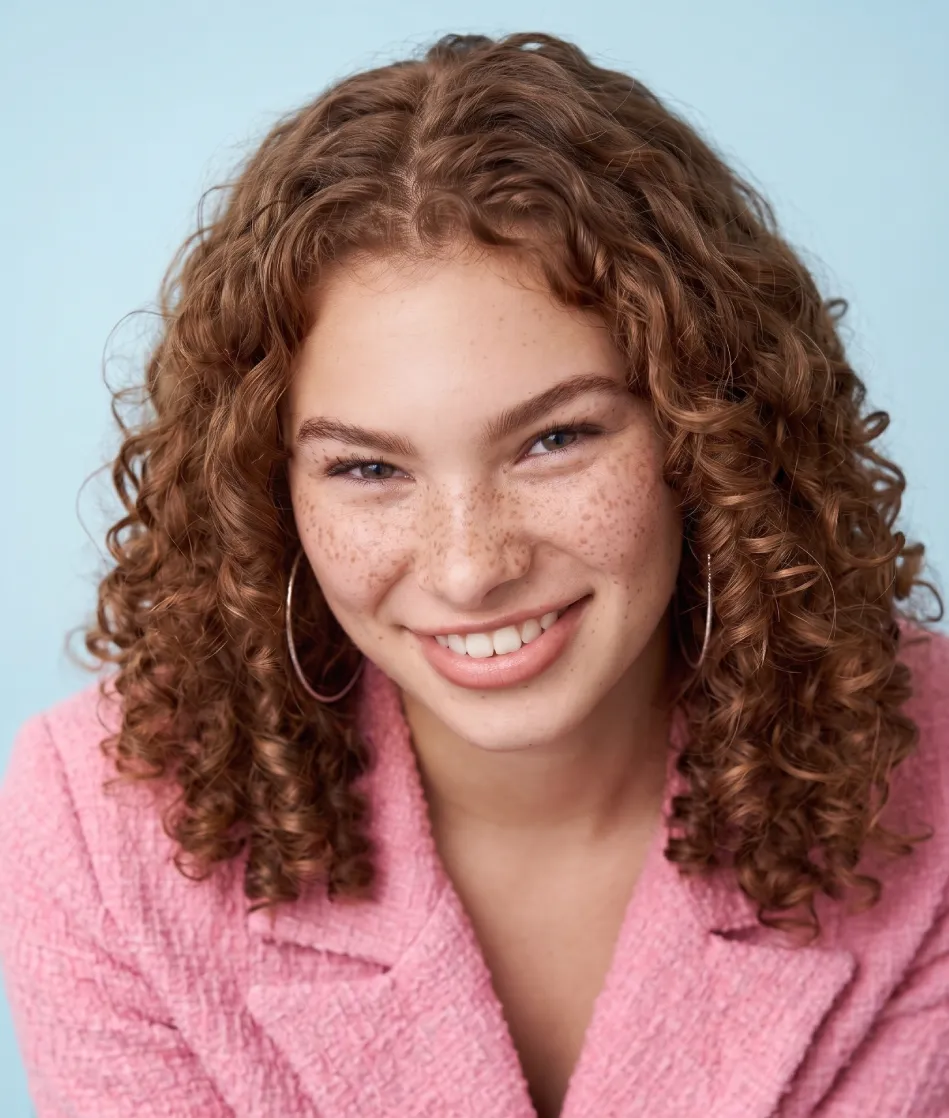 Smiling woman with red curly hair and freckles
