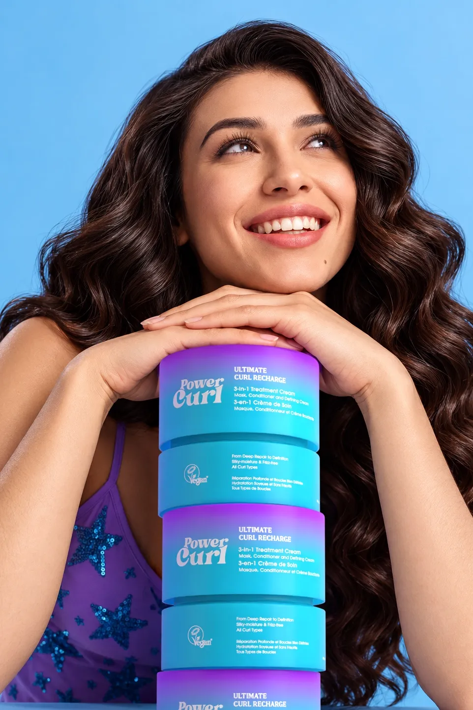 Smiling woman resting her hands on a stack of Power Curl Ultimate Curl Recharge jars